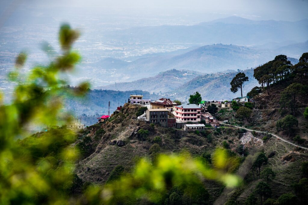 A serene village perched on a hilltop surrounded by lush mountains and scenic views.